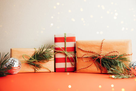 Greeting Christmas, new years background. Gifts wrapping in brown and red paper on a red and beige...