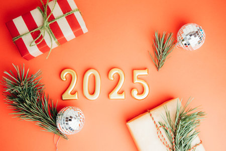 Greeting Christmas, new years background. Golden figures, numbers 2025 on a red background with gifts and pine branches. Top viewの写真素材