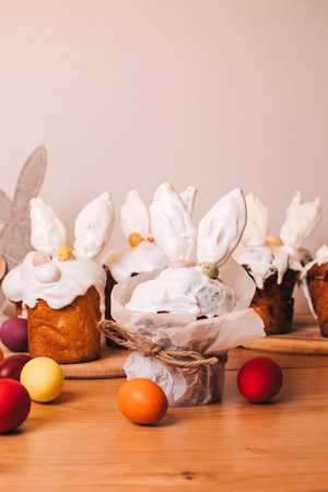 Easter cake is decorated with white meringue with ears and chocolate eggs on a wooden table. Easter background, preparation for the celebrate table. Front viewの写真素材