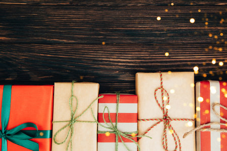 Christmas, festive background. Gifts wrapping in red and brown paper on a dark wooden background. Top viewの写真素材