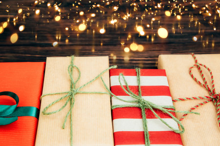 Christmas, festive background. Gifts wrapping in red and brown paper on a dark wooden background....