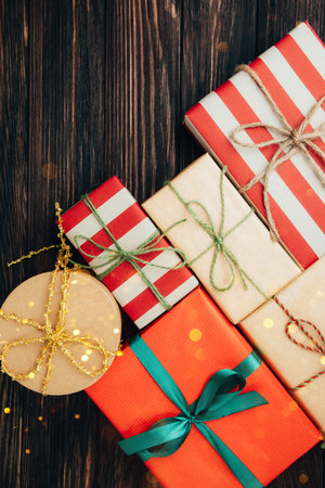 Christmas, festive background. Gifts wrapping in red and brown paper on a dark wooden background....