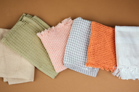 Different texture and colour kitchen towels, waffle and linen on a brown background. Top viewの写真素材