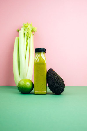 Fruit and vegetable smoothies in transparent plastic bottles. Green smoothie on a pink-green background with avocado and celery. The concept of healthy eating. Front viewの写真素材