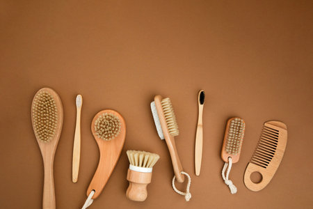 Wooden brushes, bamboo toothbrushes on a brown background. Eco friendly products. Top view