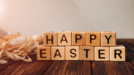 Easter background wit wooden cubes with letters. Chicken eggs on a wooden background with sun reflections. Happy Easter background. Front viewの写真素材