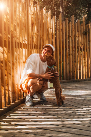 A woman walks through the park with a red little poodle. Walking with pets, dog. Spending time outdoors. Portrait human and pet. Front viewの写真素材