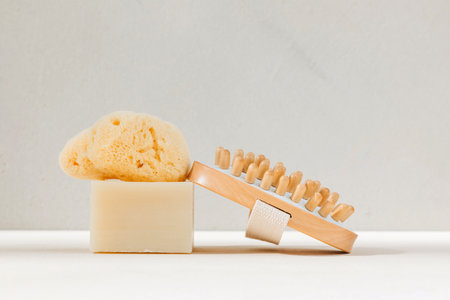 Set eco friendly bath devices. A soap bar with natural bath sponge and brush for body self-massage on a concrete background. Front viewの写真素材