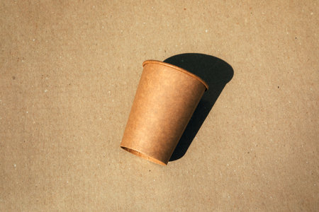 Paper cup on a brown cardboard background. Eco friendly, zero waste concept. Top viewの写真素材