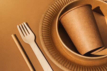 A set of paper utensils and wooden cutlery on a brown background. Eco friendly, zero waste concept. Top viewの写真素材