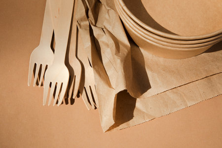 A set of paper utensils and wooden cutlery on a brown background. Eco friendly, zero waste concept. Top viewの写真素材