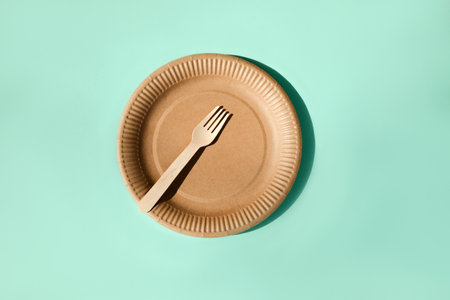 A paper utensils, plate and wooden cutlery on a blue background. Eco friendly pattern, zero waste concept. Top viewの写真素材