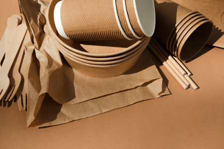 A set of paper utensils and wooden cutlery on a brown background. Eco friendly, zero waste concept. Top viewの写真素材