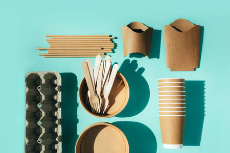 A paper utensils, plates and wooden cutlery on a blue background. Eco friendly pattern, zero waste concept. Top viewの写真素材
