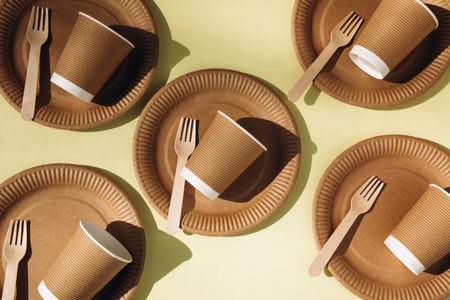 A set of paper utensils and wooden cutlery on a yellow background. Eco friendly, zero waste concept. Top viewの写真素材