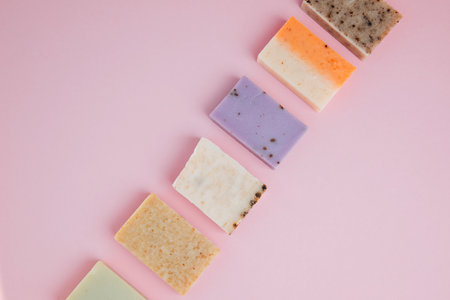 Handmade soap from natural ingredients, various herbs on a pink background. Concept of sustainable use, bath products. Top viewの写真素材