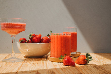 Fruit smoothie in transparent cups. Red strawberry smoothie on a wooden table. The concept of healthy eating. Front viewの写真素材