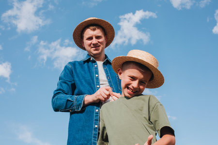 Agronomist, father and son together in agriculture field with soybeans. The man shows the boy ripe soy. Quality control of crops. Front viewの写真素材