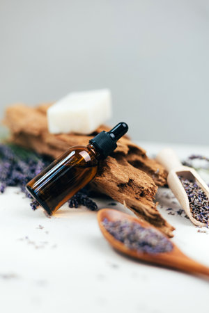 Natural cosmetics. Amber bottle with facial, bath liquid on a concrete background with lavender flowers. Front viewの写真素材