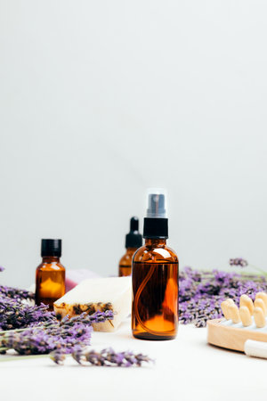 Set of natural cosmetics. Amber bottles with facial, bath liquid on a concrete background with lavender flowers. Front viewの写真素材