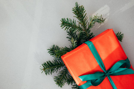 Christmas, festive background. Gifts wrapping in red paper with green ribbon on a grey background. Top viewの写真素材