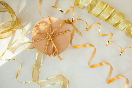 Christmas, festive background. Brown gift box with golden ribbon on a grey background. Top viewの写真素材