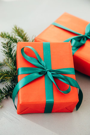 Christmas, festive background. Gifts wrapping in red paper with green ribbon on a grey background. Top viewの写真素材