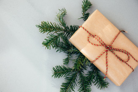 Christmas, festive background. Gifts wrapping in brown paper with green-red ribbon on a grey background. Top viewの写真素材