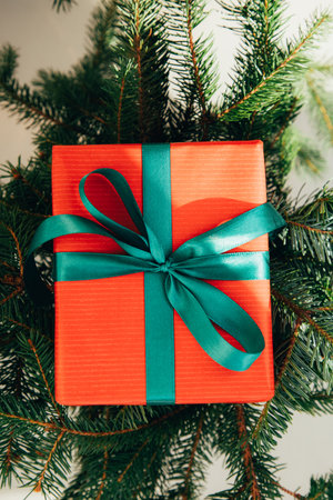 Christmas, festive background. Gifts wrapping in red paper with green ribbon on a grey background. Top viewの写真素材
