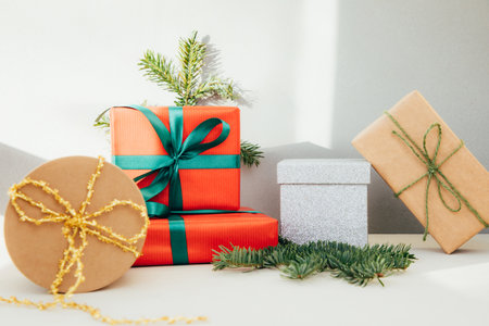Christmas, festive background. Gifts wrapping in red, brown paper with green ribbon on a grey background. Front viewの写真素材