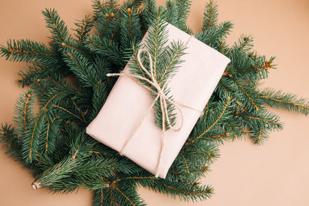 Christmas, festive background. Gifts wrapping in pink paper on a brown background with pine branches. Top viewの写真素材