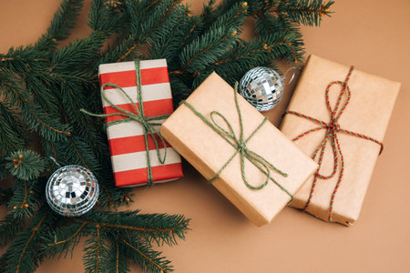 Christmas, festive background. Brown and red gift boxes with on green coniferous branches on a brown background. Top viewの写真素材