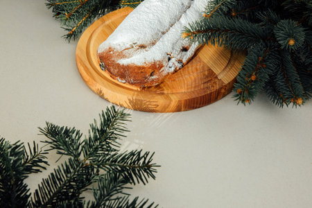 Christmas stollen on a wooden board with green branches of a Christmas tree. Christmas background, Christmas dessertsの写真素材