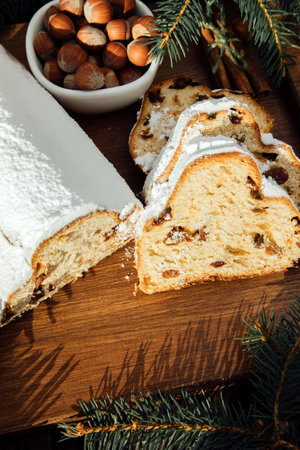 Christmas stollen on a wooden board with green branches of a Christmas tree. Christmas background, Christmas dessertsの写真素材