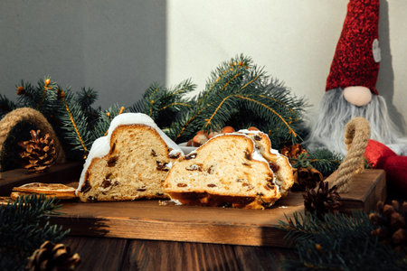 Christmas stollen on a wooden board with green branches of a Christmas tree. Christmas background, Christmas dessertsの写真素材