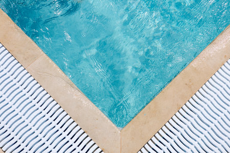 Background, water waves in the pool with sun reflection