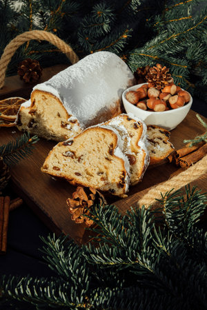 Christmas stollen on a wooden board with green branches of a Christmas tree. Christmas background, Christmas dessertsの写真素材