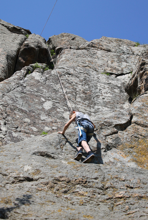 Boy climbing on the rockの写真素材