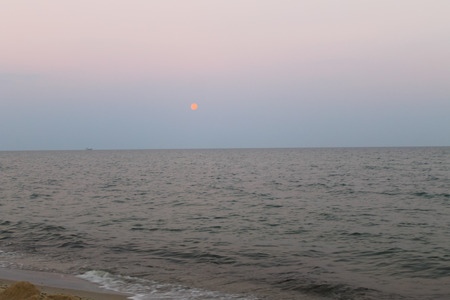 Full moon rising over the seaの写真素材
