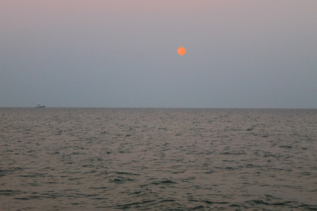 Full moon rising over the seaの写真素材