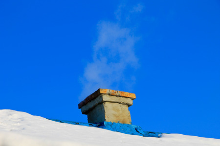 Smoke from the chimney on winterの写真素材