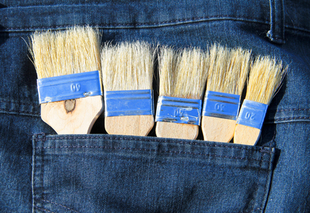 Paintbrush in the pocket of blue jeansの写真素材