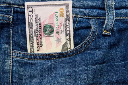 Fifty American dollars bill in the pocket of blue jeansの写真素材