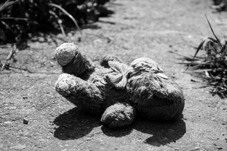 Abandoned dog doll on the pavement. Black-white toneの写真素材