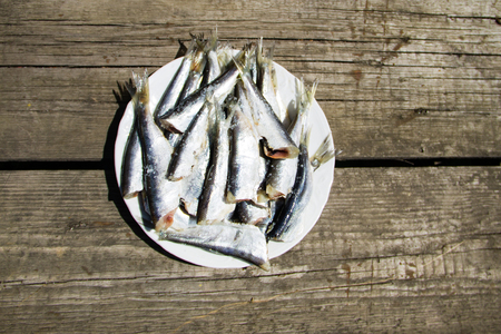 Gutted baltic herring on a plate on rustic wooden tableの写真素材