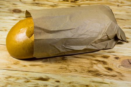 Bread packed in paper on wooden tableの写真素材