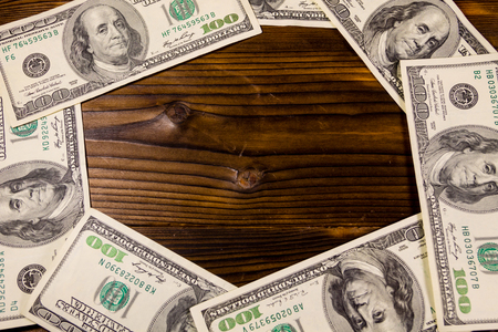 Frame of hundred dollar bills on wooden backgroundの写真素材