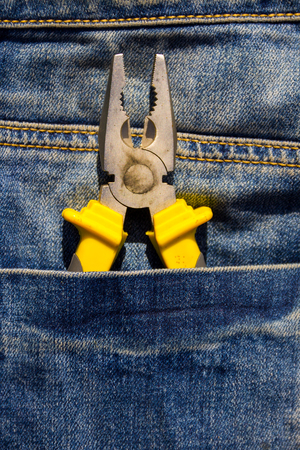 Pliers to repair in pocket of blue jeansの写真素材