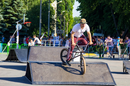 Kremenchug, Ukraine - June 5, 2017:  Extreme BMX rider in helmet in skatepark on competition. Unidentified BMX rider making tricks on festival Extreme zoneのeditorial素材