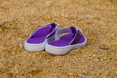 Pair of flip flops on a sandy sea beach. Summer vacation conceptの写真素材